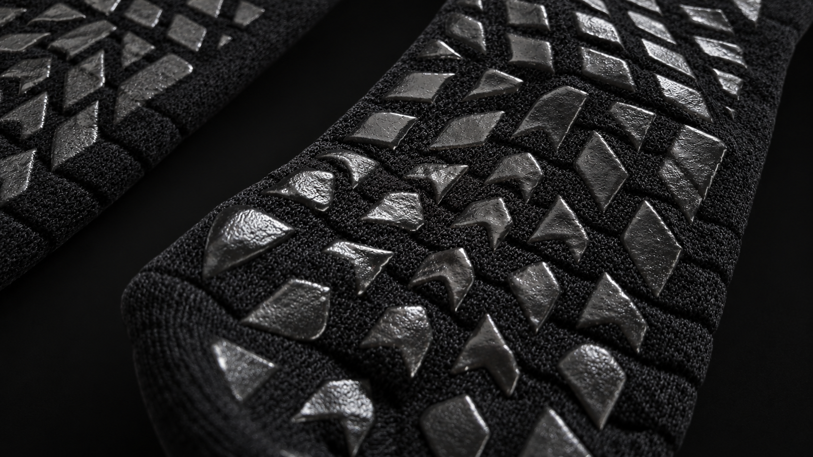 Studio-retouched close-up of actual black knit and glossy grip texture